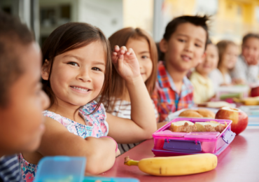 children at summer club having packed lunches